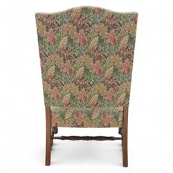 Early 20th-century Jacobean revival open oak armchair, arched padded back, and seat button upholstered  in foliate tapestry style fabric, with scroll carved arms on turned supports, raised on block supports united by turned shaped stretchers 