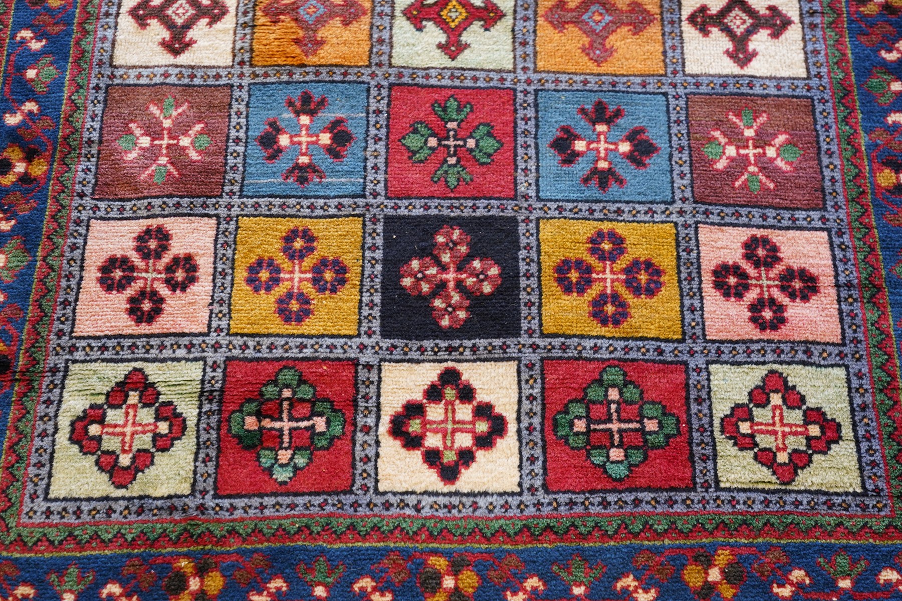 Persian Gabbeh indigo ground runner rug of garden design, the multi-coloured field decorated with five columns of panels in contrasting colours with stylised plant motifs, the guard band with trailing foliage