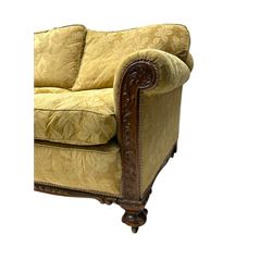 Early 20th century mahogany framed three-piece lounge suite - three-seat camelback sofa (W203cm, D105cm); pair of matching armchairs (W95cm, D96cm); upholstered in neutral foliate pattern fabric, carved with trailing leafy branches, ball and claw carved feet with brass castors 