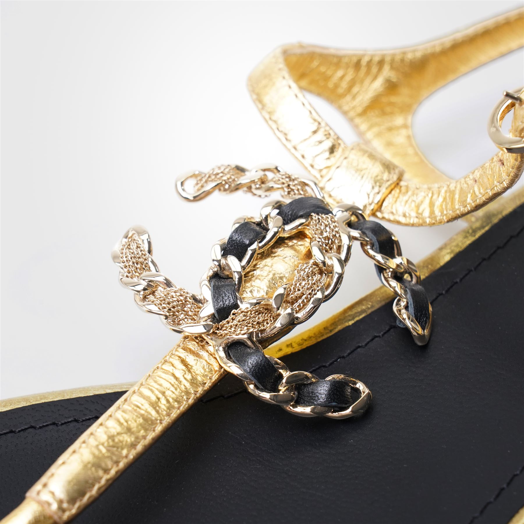 Chanel - pair of gold leather thong sandals, from the 2021 Summer Collection, the uppers centred with an interlocking gold tone CC motif in chain and leather, size 37C, unused with original dust bags