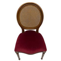 Set six French style walnut finish dining chairs, oval cane bergere backs over serpentine seats upholstered in red, flower head carved fluted supports