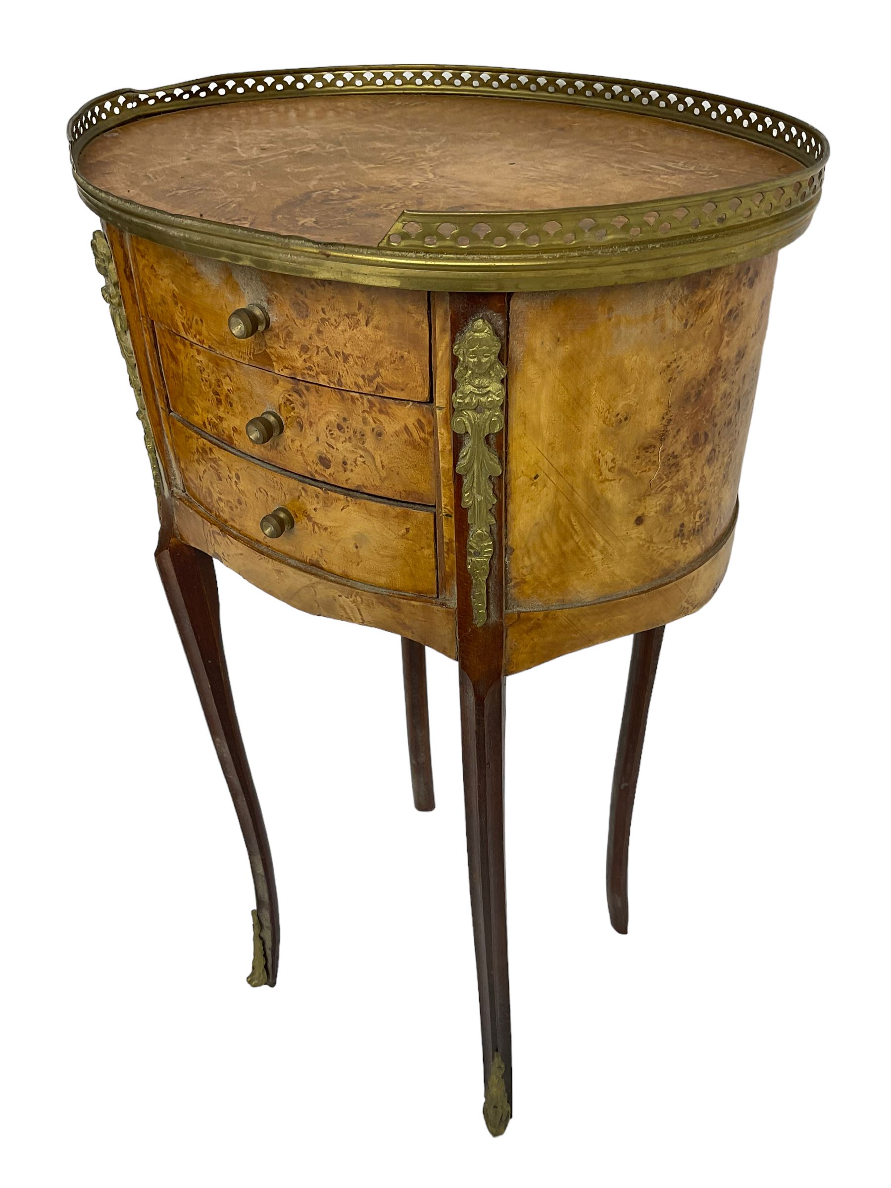 Late 20th century French design figured elm and bedside table, raised pierced gilt metal gallery over oval top, fitted with three mahogany lined drawers flanked by gilt metal mounts of female mask and foliate form, on cabriole supports