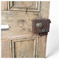 Victorian stripped pine four-panel door, the raised fielded panels within carved foliate and moulded surrounds, with iron lock and fittings and brass knob handle