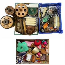 Treen bobbin stands, vintage spools, various sewing implements including vintage needle tins, pin cushions, thread dispenser etc, stationary including a blotter and pens etc in three boxes
