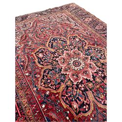 Antique Persian coral ground carpet, the large central floral pole medallion with extending foliate designs, the thick guarded indigo border with repeating flower heads and circles