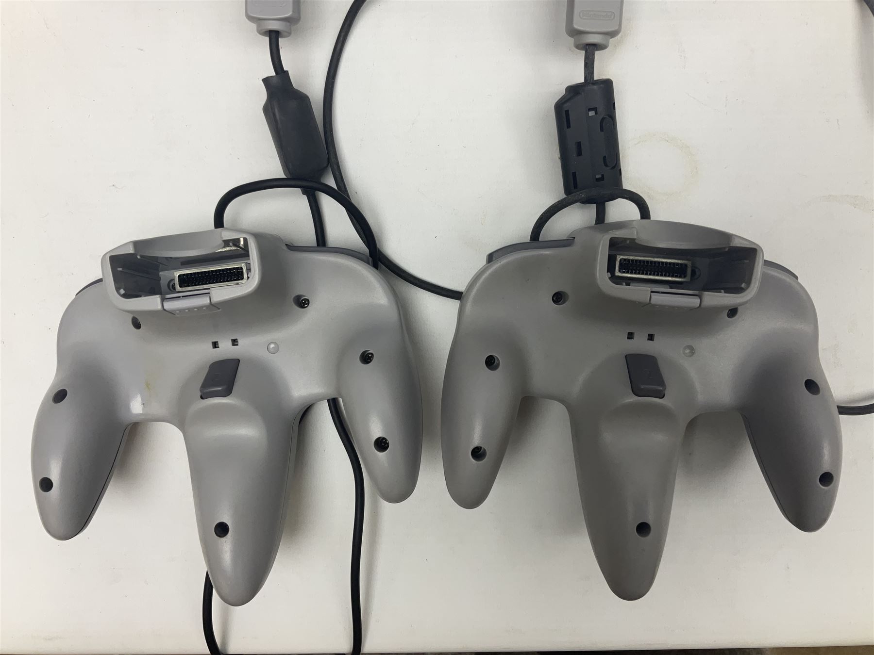 Nintendo 64 console, two controllers, games and accessories. Accessories to include the ‘Tremorpak’ and ‘Spook’ 2 Phono plugs and a S-VHS plug with adapter, both in original boxes. Games to include ‘Golden Eye 007’, ‘Doom 64’, ‘Killer Instinct Gold’, ‘Tetrisphere’, ‘F-1 World Grand Prix’, ‘Pilotwings 64’ and ‘Lylatwars’ with ‘Rumble Pak’, all with original boxes and instruction manuals. ‘Star Wars Episode I Racer’ game cartridge in Shadows of the Empire box. 