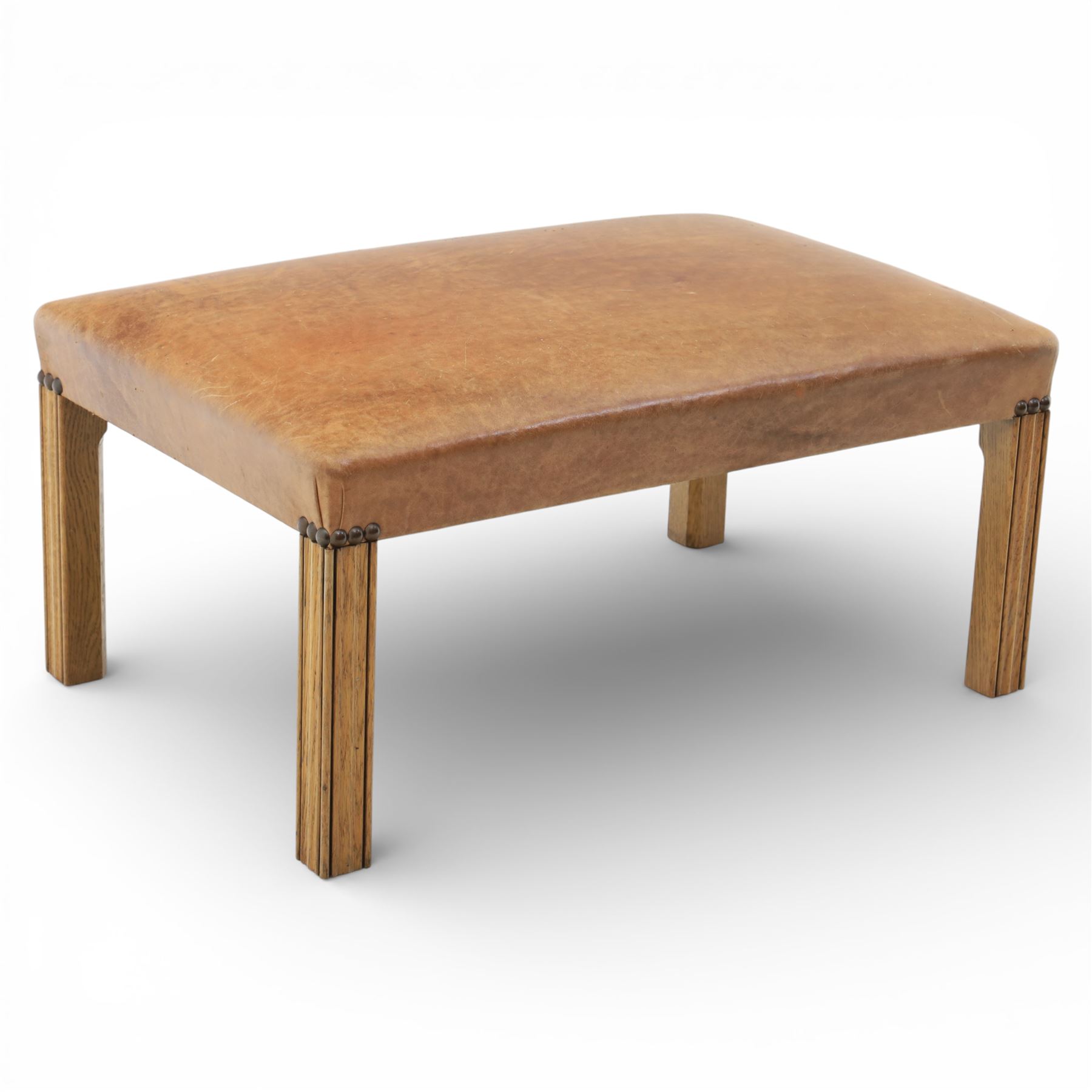 Modern tan leather stool, with studded detailing above a reeded stile supports terminating in metal caps