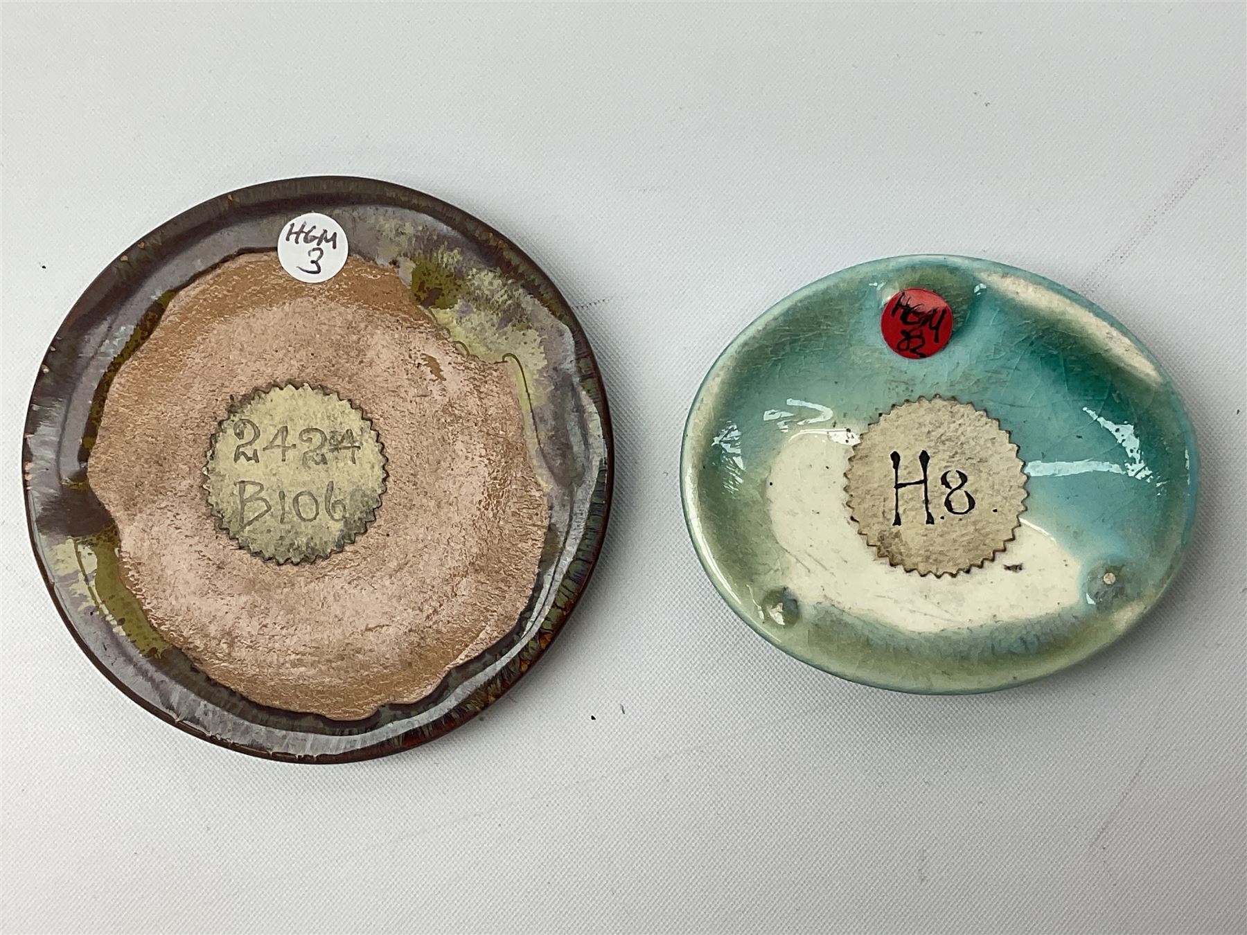 Henry George Murphy (1884-1939), collection of seven Arts & Crafts glazed ceramic roundels, of circular and oval form, five in tones of red and brown and two in tones of blue, turquoise and green in soufflé and high fired finishes, largest example D6.5cm