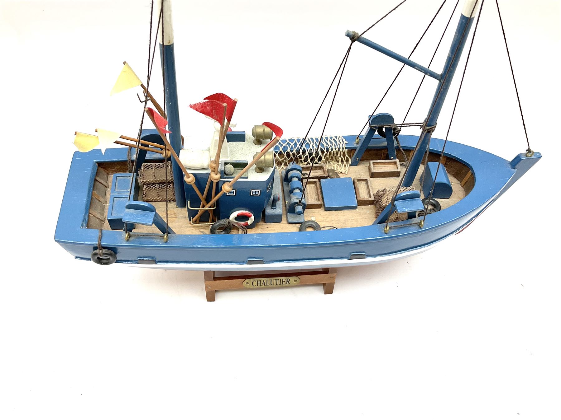Wooden model of RMS Titanic, on a fixed black stand bearing plaque inscribed 'Titanic 1912', L54cm, H22cm, together with model of a sloop, gaff rigged on stand bearing plaque inscribed 'Sloop' L32cm, H42cm; and model of a fishing trawler on a stand bearing plaque inscribed 'Chalutier' L35cm, H28cm (3)