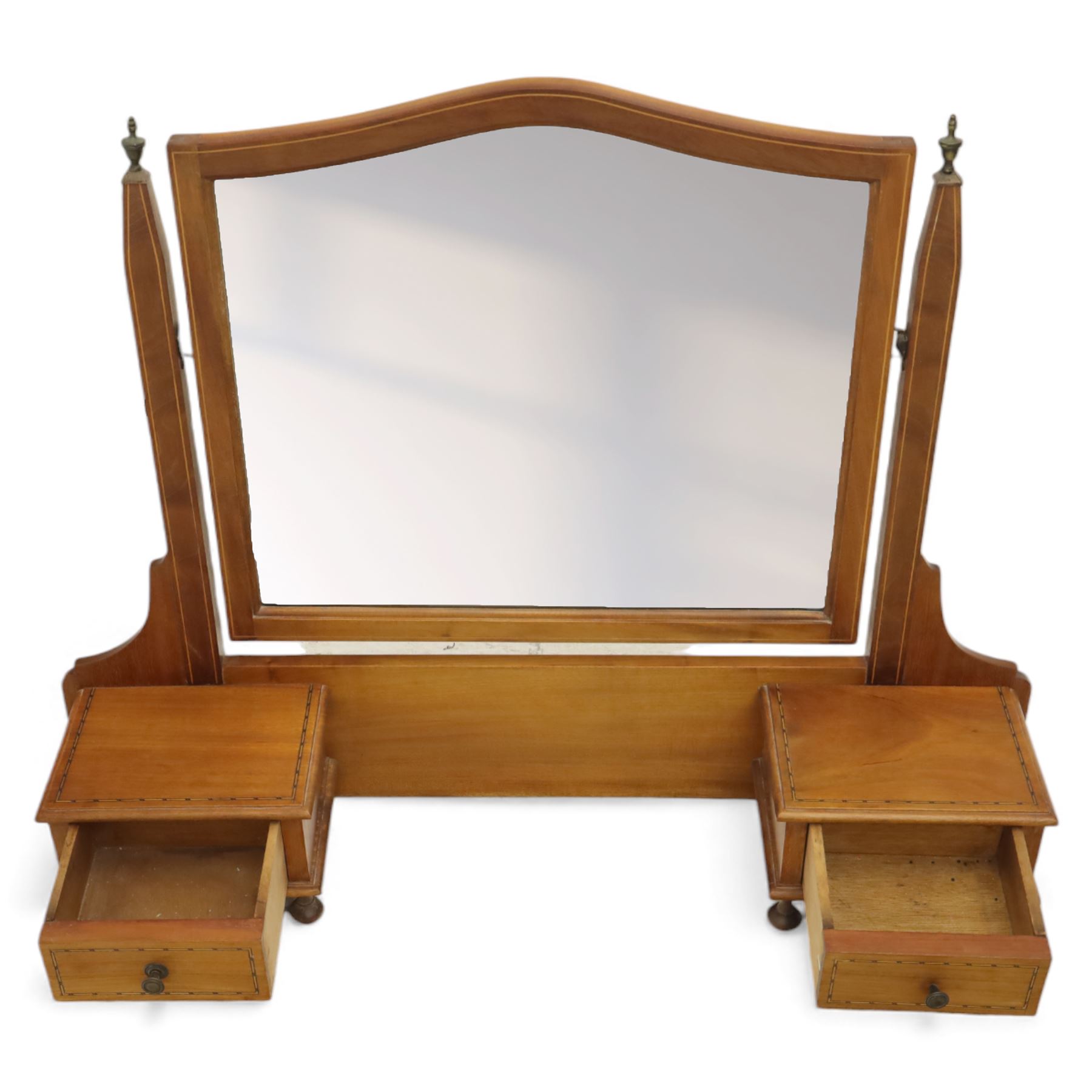 Two early 20th century mahogany swing dressing mirrors, comprising one with arched rectangular plate in a moulded frame on shaped supports, flanked by two inlaid trinket drawers (H 69cm, W 88cm, D 20cm), together with another rectangular plate mirror on turned supports upon bun feet (H 58cm, W 48cm, D 23cm)