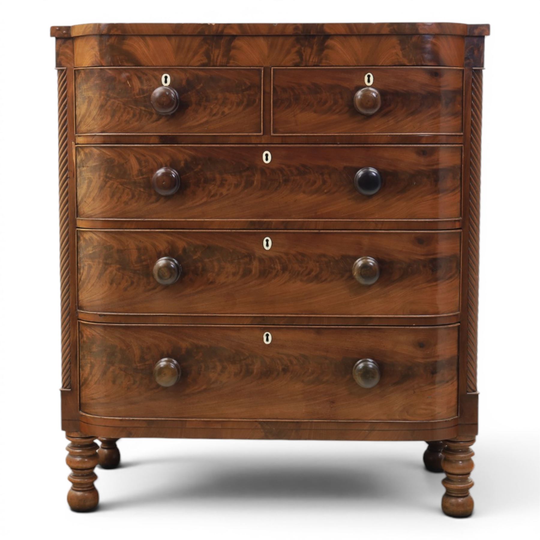 Victorian mahogany bow fronted chest, fitted with two short and three long drawers, flame mahogany front, bone escutcheons and turned wooden handles, quarter barley twist columns, raised on turned supports