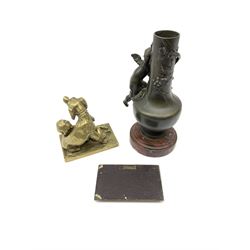 A bronzed spelter vase detailed with a fruiting vine and mounted with a cherub, raised upon a circular stepped red marble effect base, overall H24cm, a brass figure modelled as a dog and child, H11.5cm, and a base metal plaque illustrating the last supper in relief, H7.5cm L12cm. (3). 
