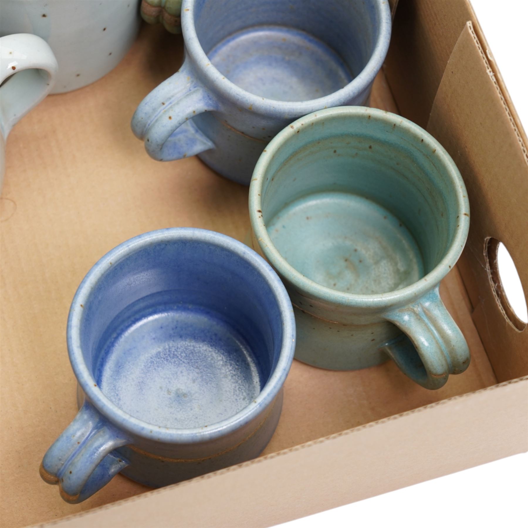 Tony Gant (British 20th Century) - set of six studio pottery stoneware mugs, in various blue glazes, with impressed marks to bases, together with two other studio pottery mugs, unmarked (8)