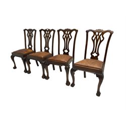 Set four George III Chippendale-style mahogany dining chairs, shaped serpentine cresting rail with pierced and splat back, drop-in sprung seat upholstered in tan leather, raised on scroll and foliate carved cabriole supports with ball and claw feet