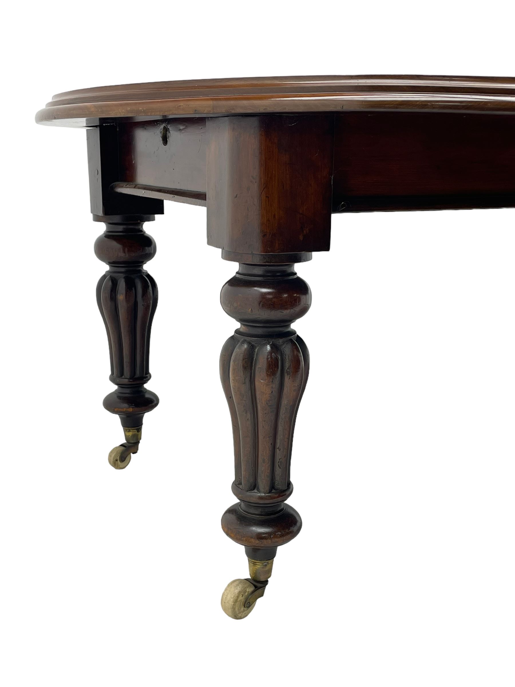 Victorian mahogany extending dining table, circular telescopic extending top with moulded edge, two additional leaves, on turned and lobe carved supports with brass and ceramic castors 