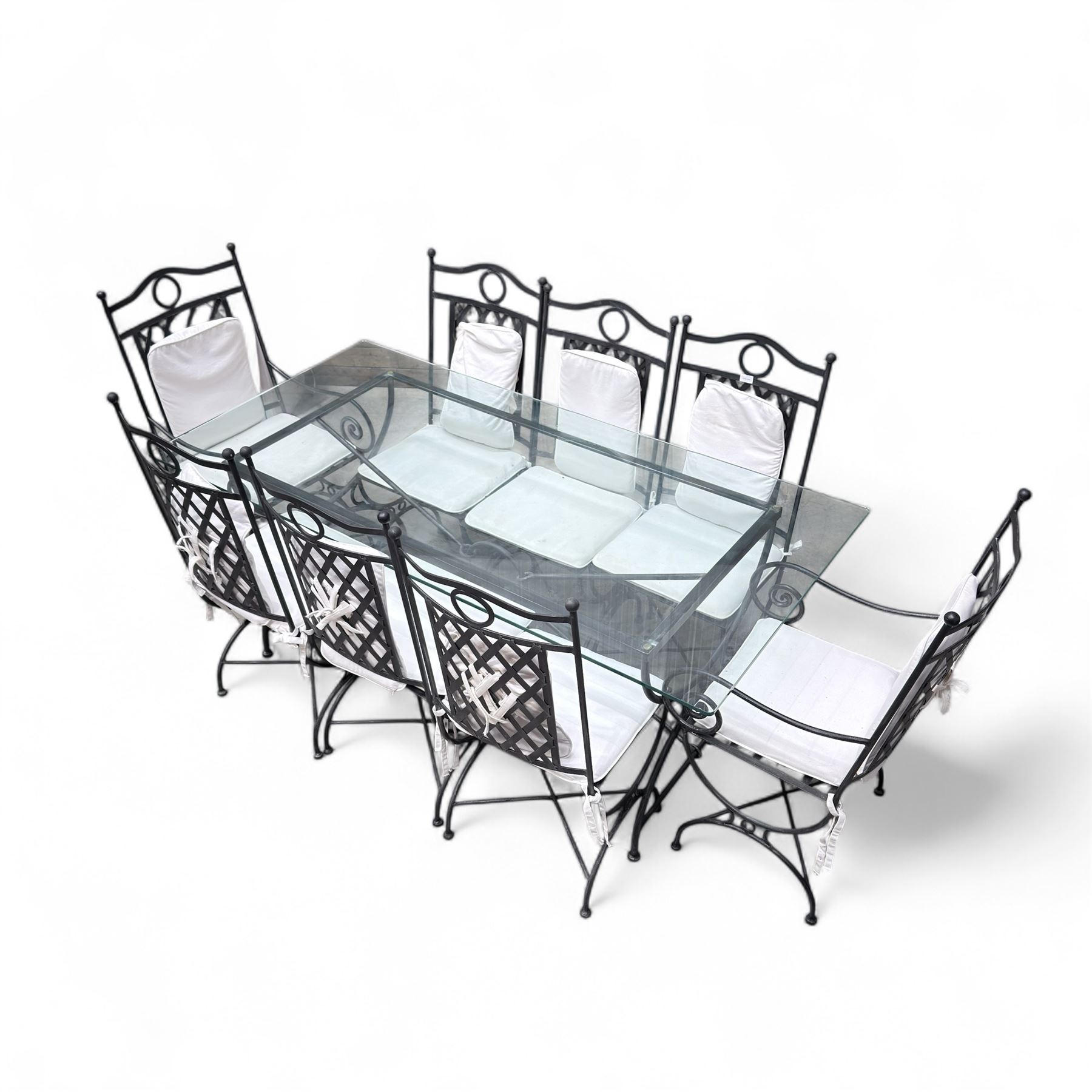 Wrought steel rectangular conservatory dining table, with glass top; and six, four side and two armchairs, with lattice backs and X framed bases, loose cushions