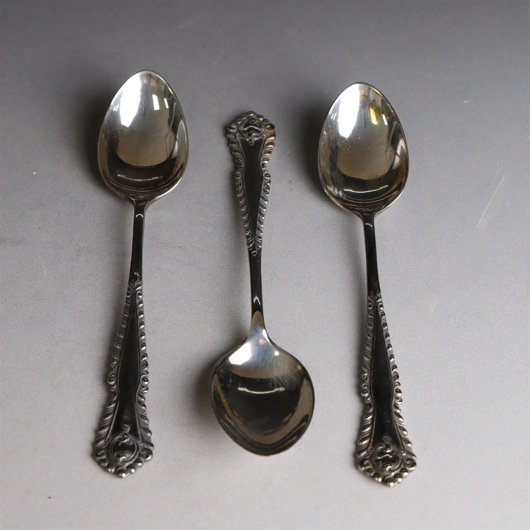 Set of six silver teaspoons and sugar tongs, with embossed foliate decoration, hallmarked I S Greenberg & Co, Birmingham probably 1917
