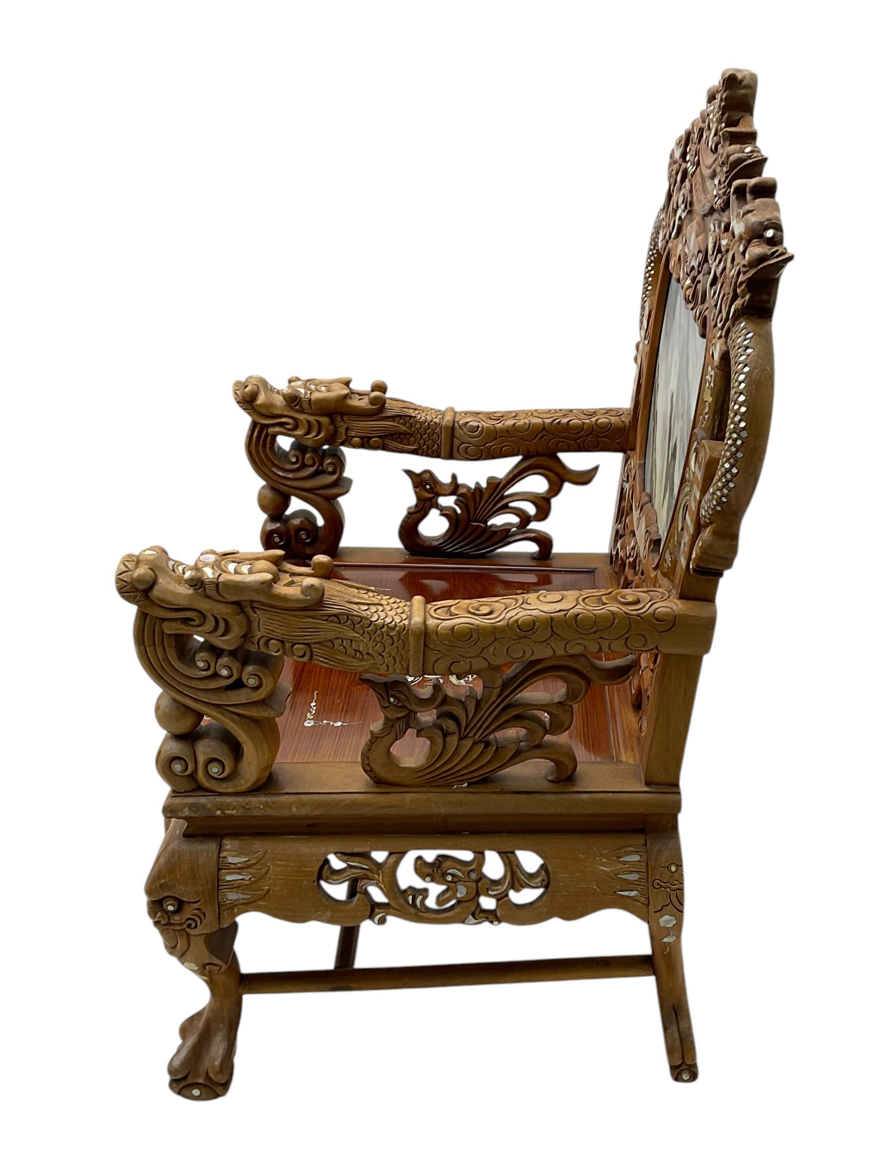Pair of Chinese hardwood throne chairs, the back with grey marble inset surrounded by carved dragons and masks, inlaid with mother of pearl, the arm terminals carved with dragons, panelled seats inlaid with flowers and foliate motifs, on ball and claw carved cabriole feet