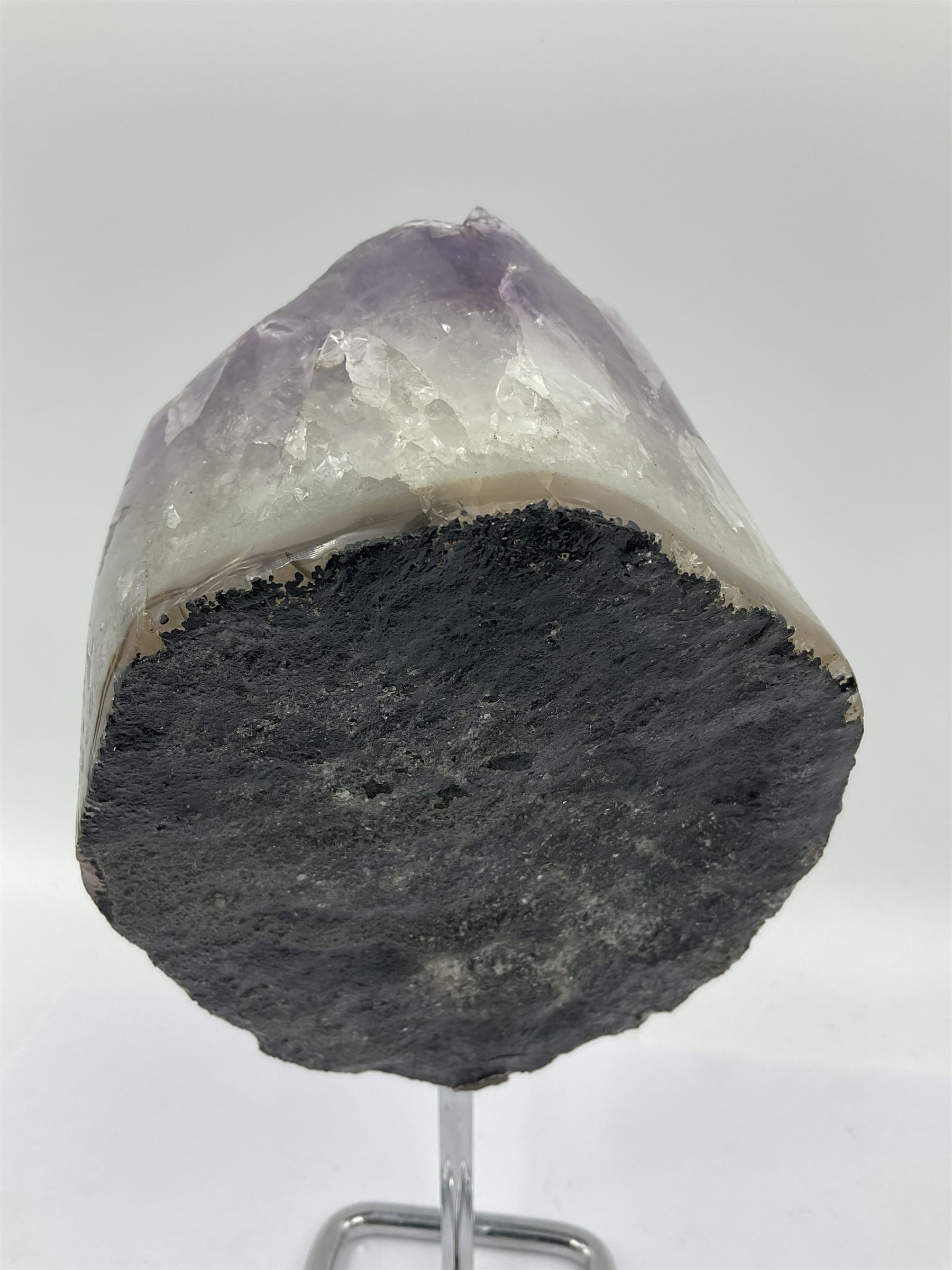 Amethyst crystal geode cluster, with large well-defined crystals, upon a metal stand, H21cm