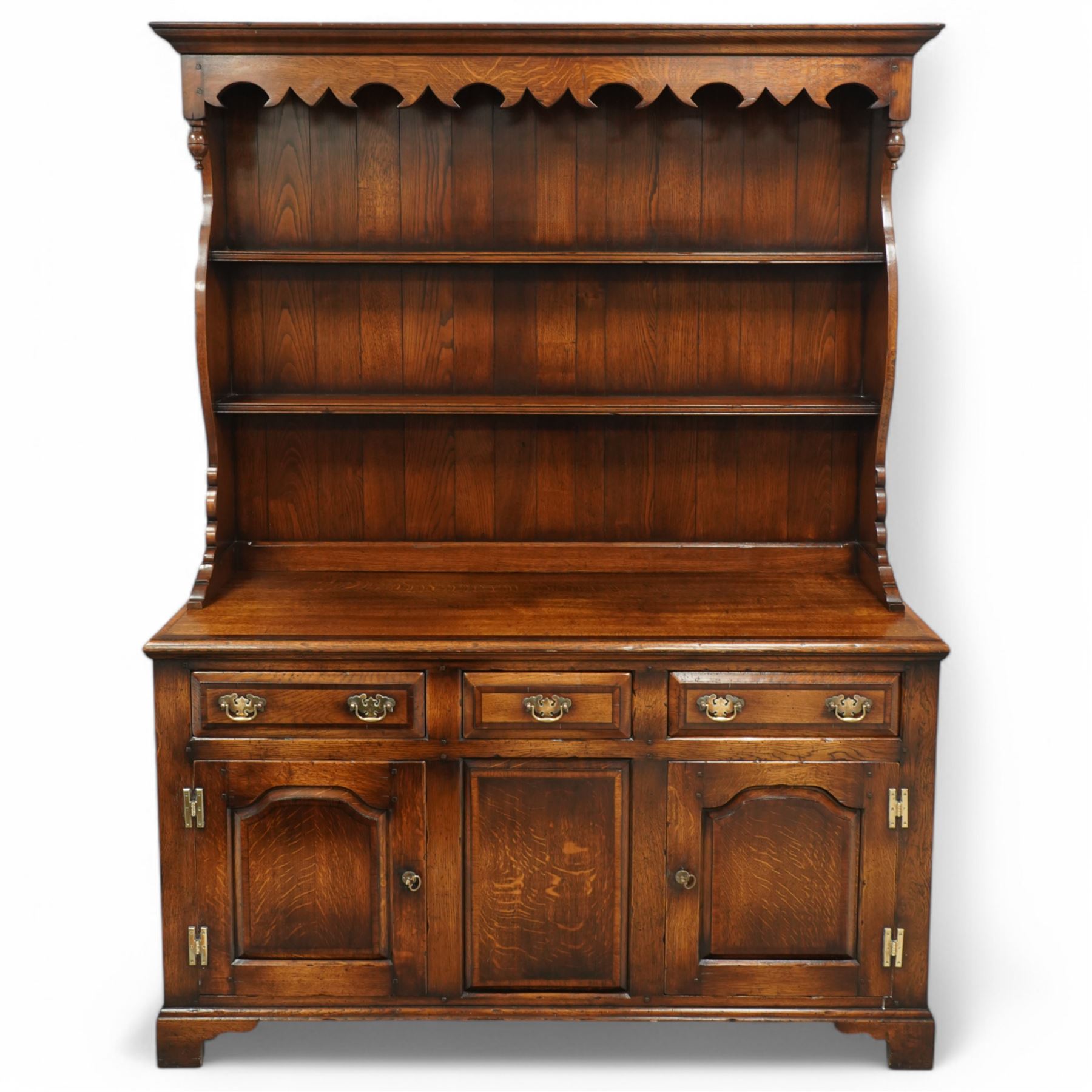 Gostins of Liverpool - Georgian design oak dresser, the two-tier rack with moulded cornice over shaped frieze and end supports, the dresser base with moulded rectangular top over tree drawers and two cupboards, panelled sides, on bracket feet