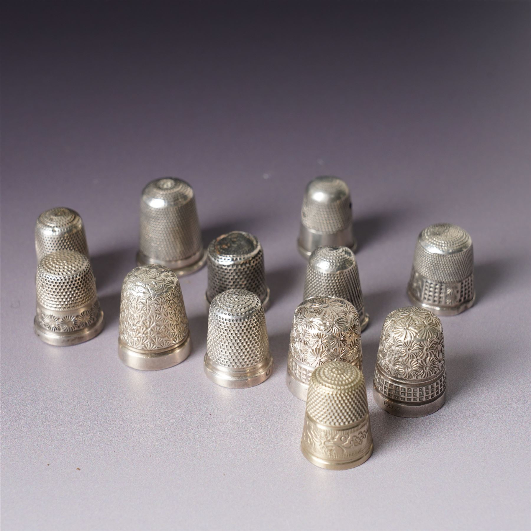 Three George IV silver fiddle pattern teaspoons London 1824, pair of George IV silver condiment spoons, four various silver teaspoons, three Charles Horner thimbles, three other silver thimbles, plated thimbles, two plated decanter labels and a plated Coronation spoon