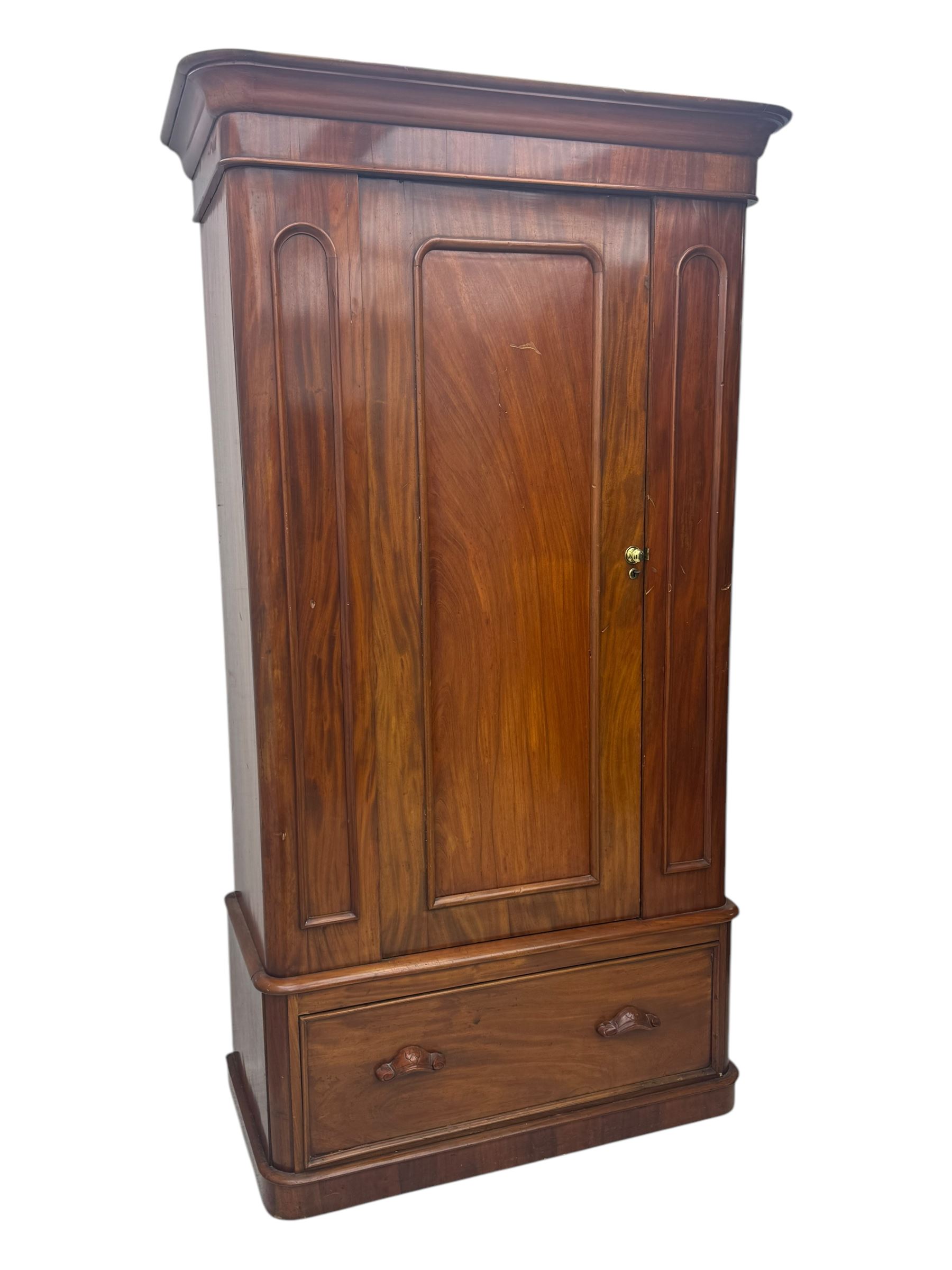 Large Victorian mahogany wardrobe, projecting moulded cornice over single panelled door enclosing hanging hooks and sliding rail, the base fitted with full width drawer, on plinth base

