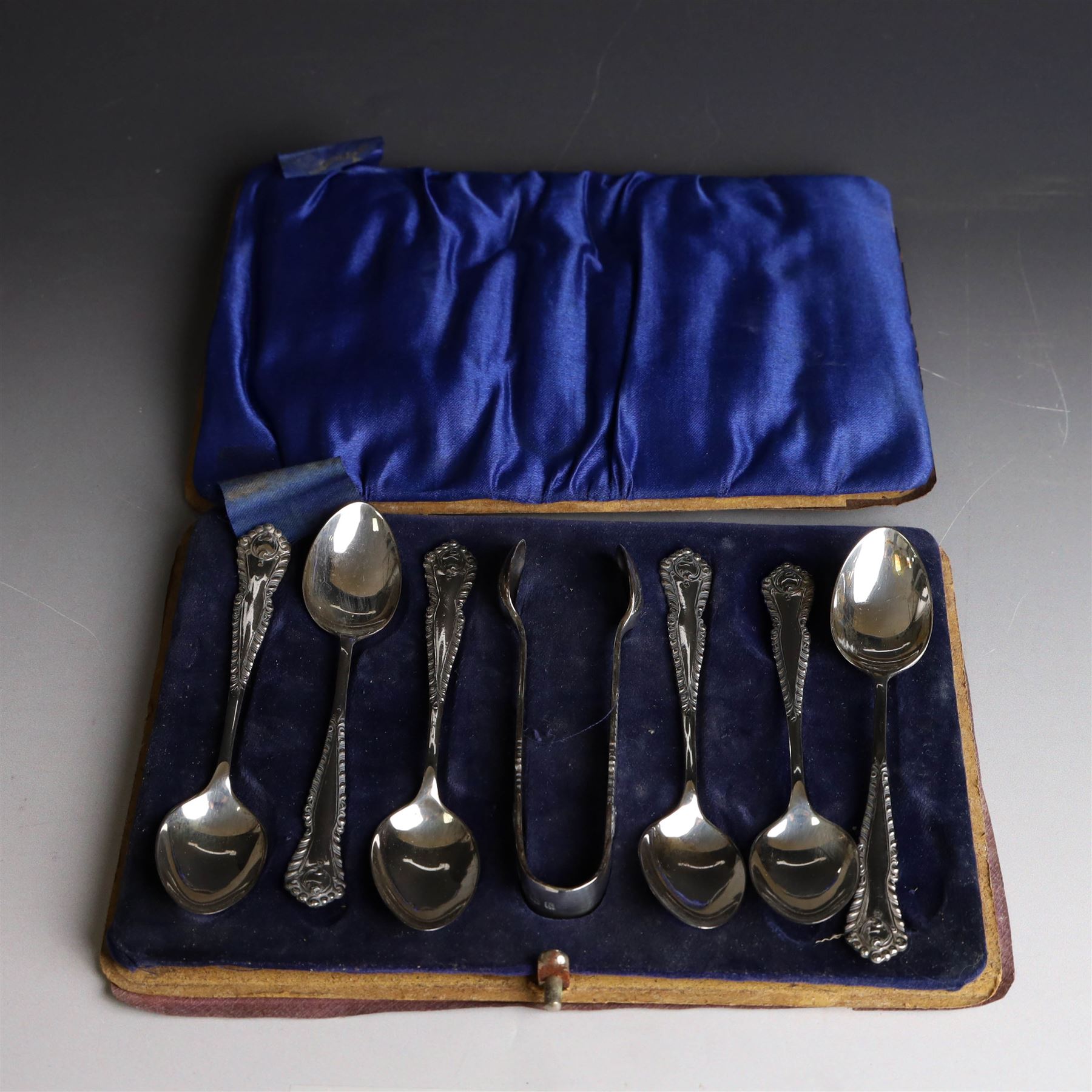 Set of six silver teaspoons and sugar tongs, with embossed foliate decoration, hallmarked I S Greenberg & Co, Birmingham probably 1917