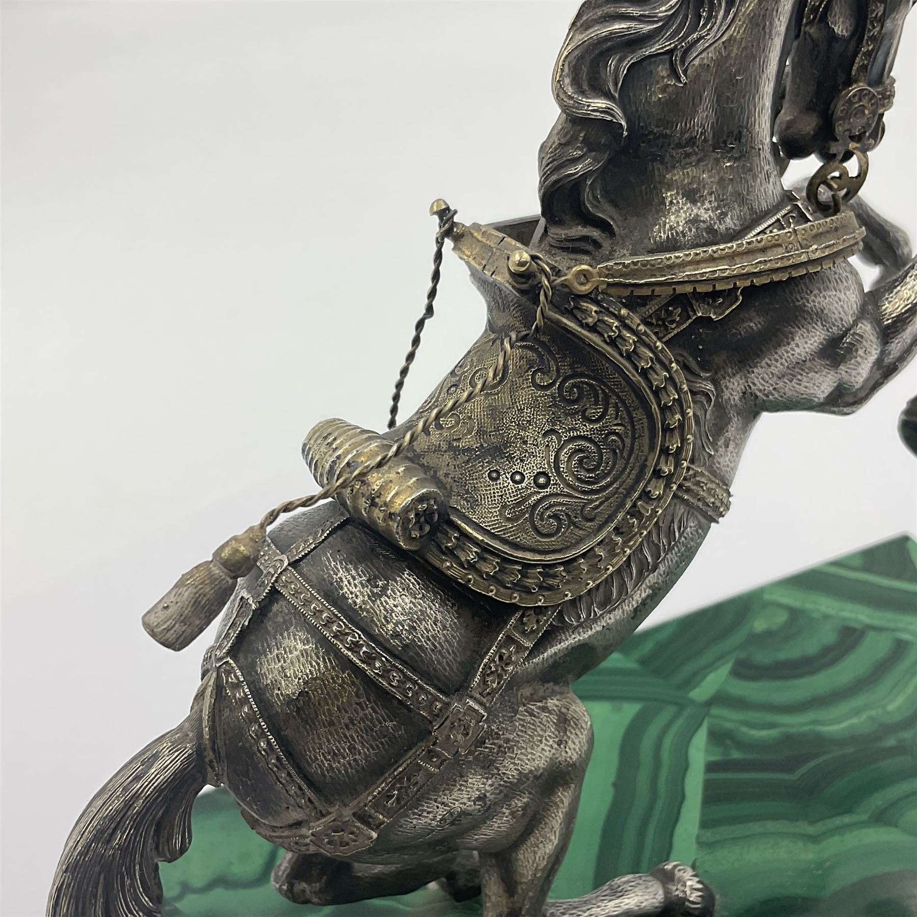 Modern silver model of a rearing horse, with ornate parcel gilt saddle and bridle, mounted upon a rectangular base, decorated with malachite panels to each side and upon four gilt bun feet, horse stamped 925, overall H14.5cm