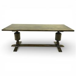 20th century oak refectory style dining table and eight chairs (6 + 2), rectangular top on two large carved baluster pedestal supports with leaf decoration, on splayed trestle bases joined by a stretcher, with eight matching oak dining chairs, each with Yorkshire rose carved cresting rail, panel back and solid seat, raised on turned supports united by stretchers