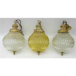  Set of three matching moulded glass light fittings with foliate cast fittings, two clear glass and one light amber, H43cm approx excluding chain (3)  