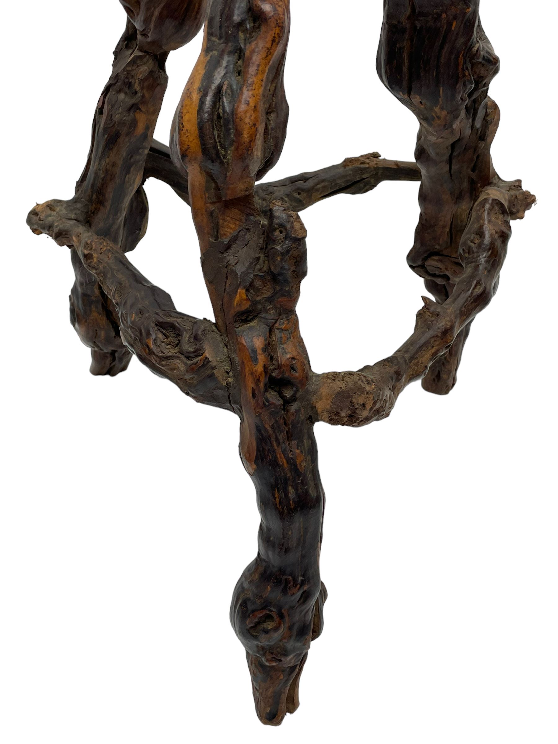 Mid-20th century French grapevine and walnut bow-front wine tasting bar, the curved counter top supported by sculptural grapevine roots, fitted with single shelf and raised on rustic vine feet (W100cm H101cm); with a pair of matching bar stools, the circular top raised on three gnarled root supports united by stretchers (W50cm H70cm)