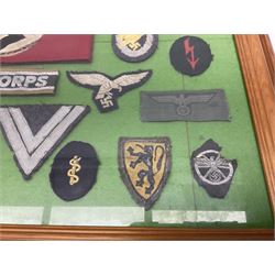 Framed display of thirty-four WWII German cloth badges including Luftwaffe pilot, Paratrooper, Afrikakorps cuff title, sleeve insignia for 'SS' Foreign Volunteers, various breast eagles including Luftwaffe, Army etc, RAD badges, Party Armband, rank and trade insignia, cap insignia etc; 40 x 50cm in modern pine frame