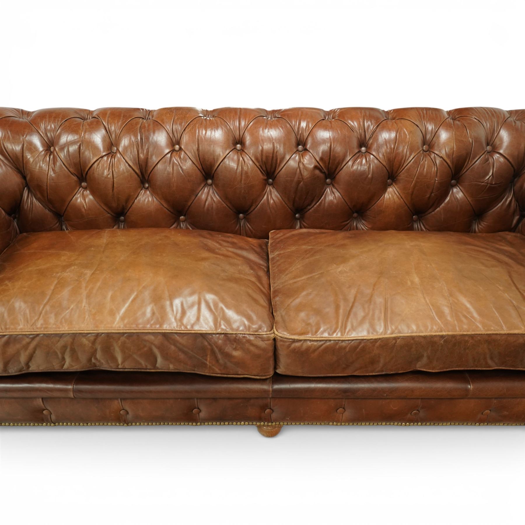 Timothy Oulton for Halo - three seat chesterfield sofa, deep button tufted back and arms in tan leather, loose seat cushions, studded detail to the scrolled arms and lower frieze, raised on turned bun feet