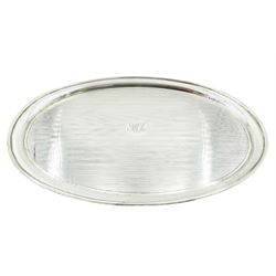1920's silver tray, of oval form with engine turned decoration and central panel engraved with monogram, hallmarked Birmingham 1924, makers mark worn probably Docker & Burn Ltd, L33cm, approximate weight 14.43 ozt (449 grams)