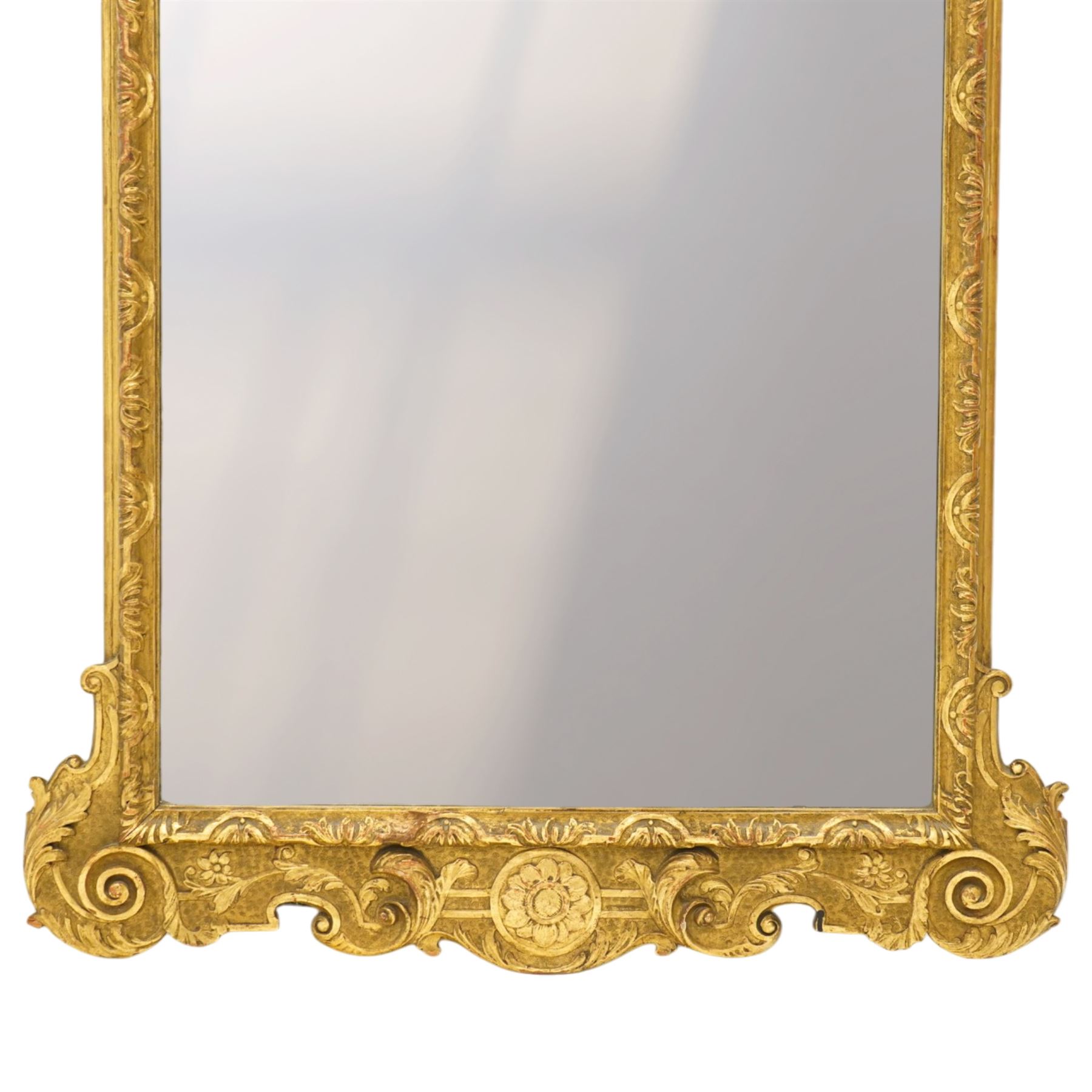 In the manner of Thomas Johnson - circa 1900 Georgian Revival giltwood wall mirror, the shaped rectangular plate within a foliate and scallop carved slip and richly ornamented frame, surmounted by a pierced cartouche crest centred with a protruding relief carved winged cherub mask and issuing scrolling acanthus and floral ornament, the sides with eagle masks over acanthus scrolls, terminating in a shaped apron with moulded rosette and spiralling acanthus leaves