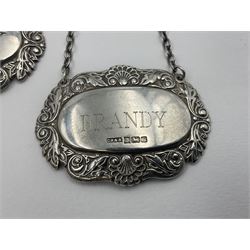 Five modern silver decanter labels, to include three similar Sherry and Brandy examples embossed with scrolls, two hallmarked C Robathan & Son, Birmingham 1989, and one hallmarked Laurence R Watson & Co, Birmingham 1987, together with a scotch example, hallmarked A Marston & Co, Birmingham 1970, and a larger sherry example, embossed with fruiting vines, hallmarked A Marston & Co, Birmingham 1993