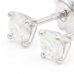Pair of 18ct white gold diamond earrings, each stud four claw set with a single round brilliant cut diamond, stamped 750, total diamond weight approx 1.05 carat