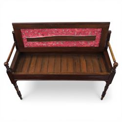 Early 20th century mahogany hall bench, spindle turned back with shaped top rail and open arms terminating in ball finials, upholstered seat within a fluted frieze, raised on turned tapering supports