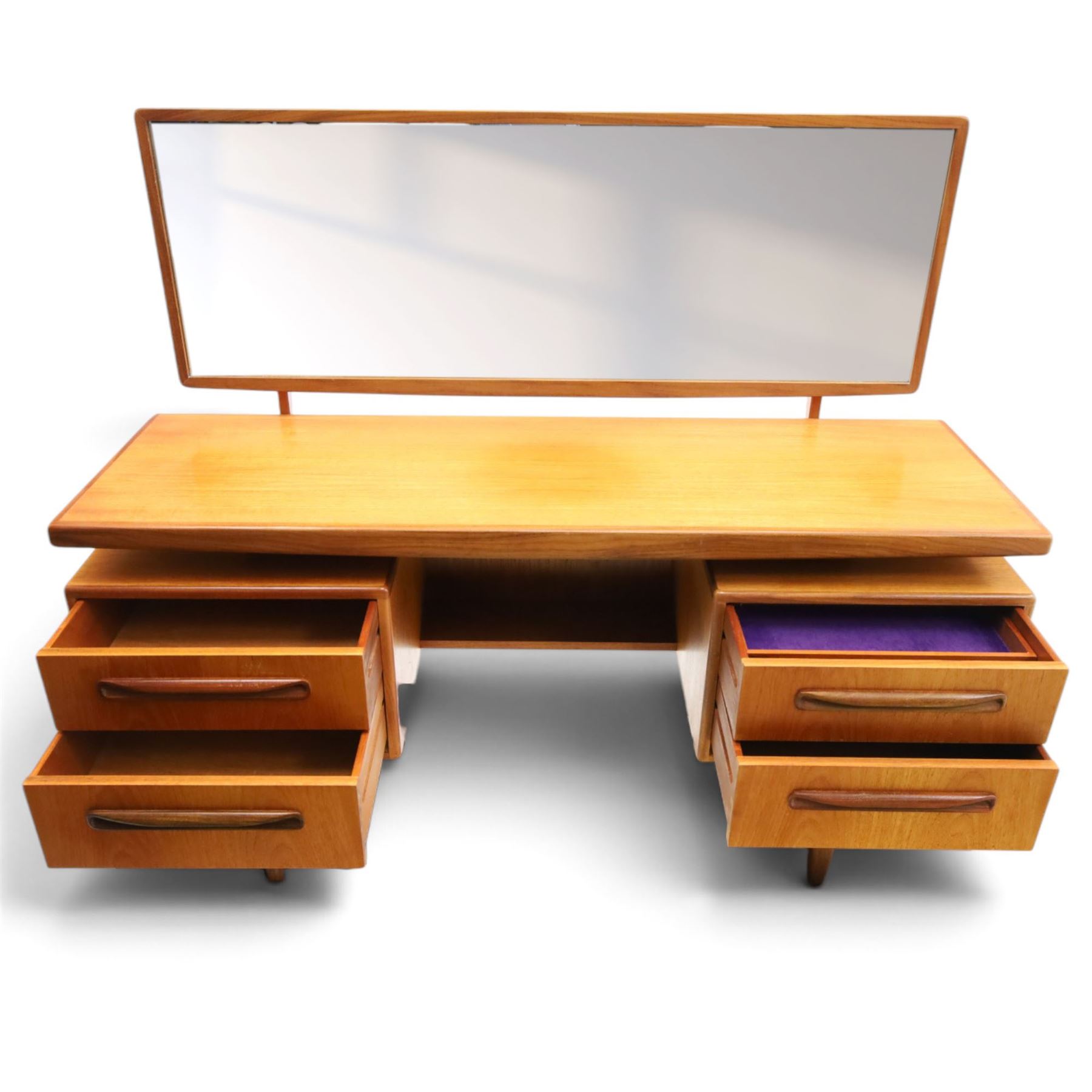 G-Plan - ‘Fresco’ teak dressing table, rectangular top with raised rectangular mirror, fitted with four drawers arranged as twin pedestals with sculpted handles, central knee-hole, on tapering supports
