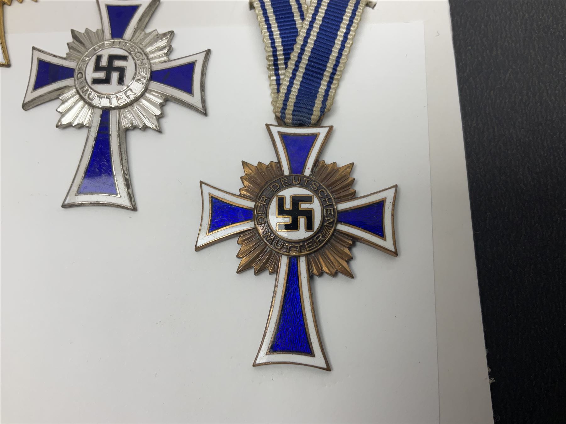 WWII set of three German Mother's Crosses, 1st Class in gilt, 2nd Class in silver and 3rd Class in bronze; all with ribbons (3)