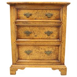 Small 20th century burr oak chest, the figured top over three graduated drawers with moulded fronts and pierced brass handles, on shaped feet