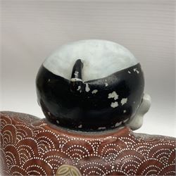 Japanese Fukusuke good fortune figure, modelled as a kneeling male figure holding a fan, dressed in traditional Samurai robes, H15.5cm