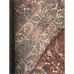 Large Persian red ground rug/carpet, the field decorated with multiple stylised motifs and quadruple pole medallion, six band repeating border, 314cm x 226cm