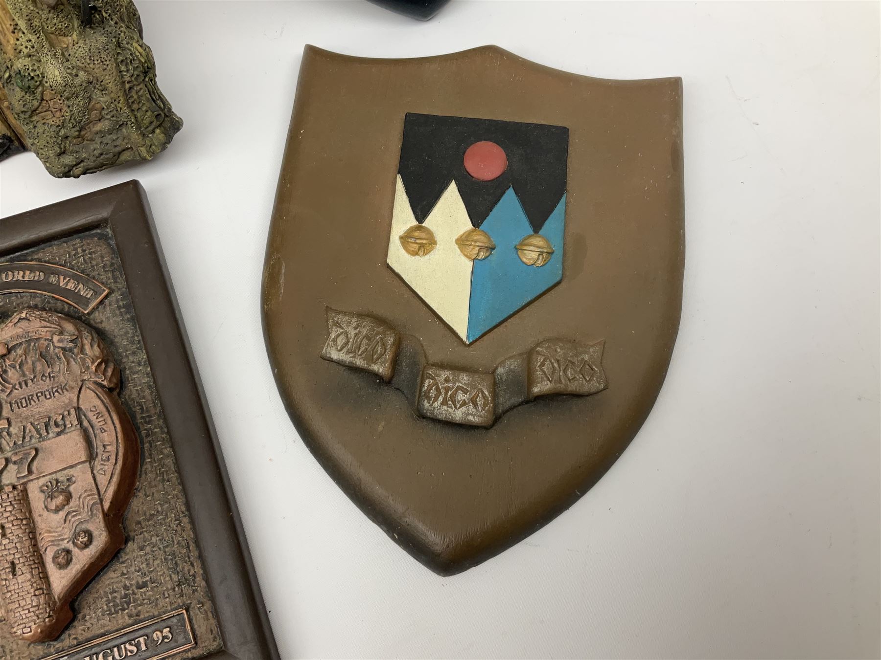 Terry Pratchett Discworld plaques, designed by Clarecraft, comprising 'the First Discworld Event Clarecraft August 95', the collectors guild joining shield, the fools guild DW99C, the seamstresses guild DW98C, the musicians guild DW00C together with 'Door of the mended drum' wall hanging DW17. 