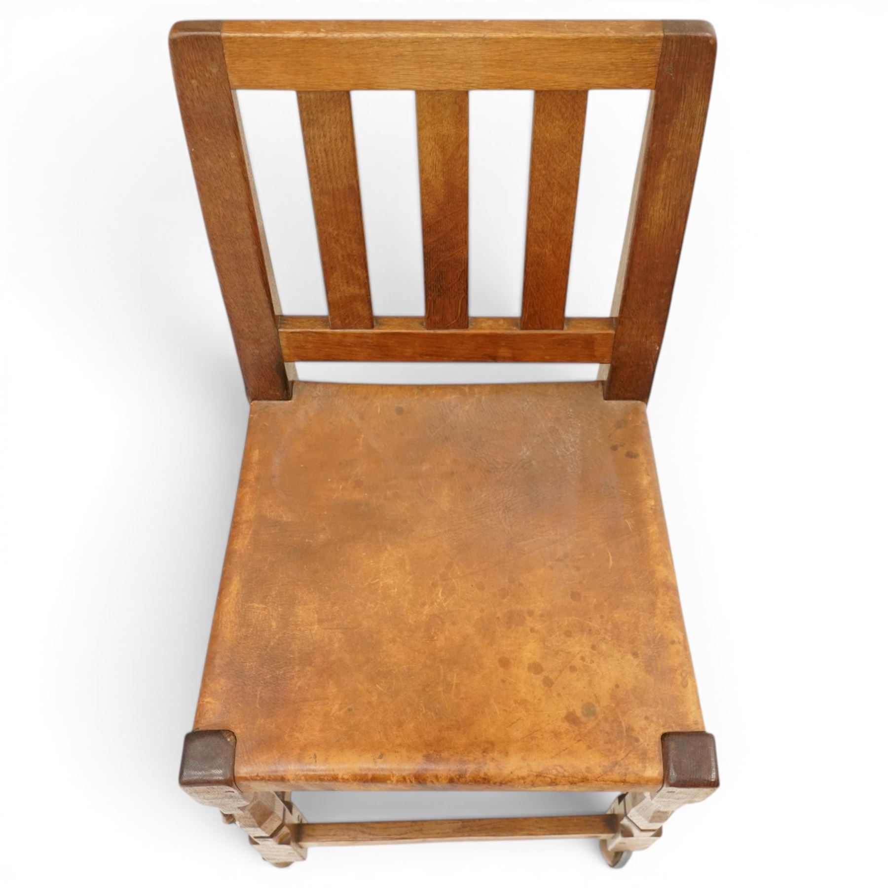 Mouseman - 1940s oak side chair, the slat-back over a slung leather seat, raised on octagonal front supports united by box stretcher, carved with slim mouse signature, by the workshop of Robert Thompson of Kilburn