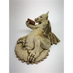 Zell Osbourne (British, Contemporary), Bookworm, a Studio Pottery figure modelled as a recumbent dragon with book, L21cm. 