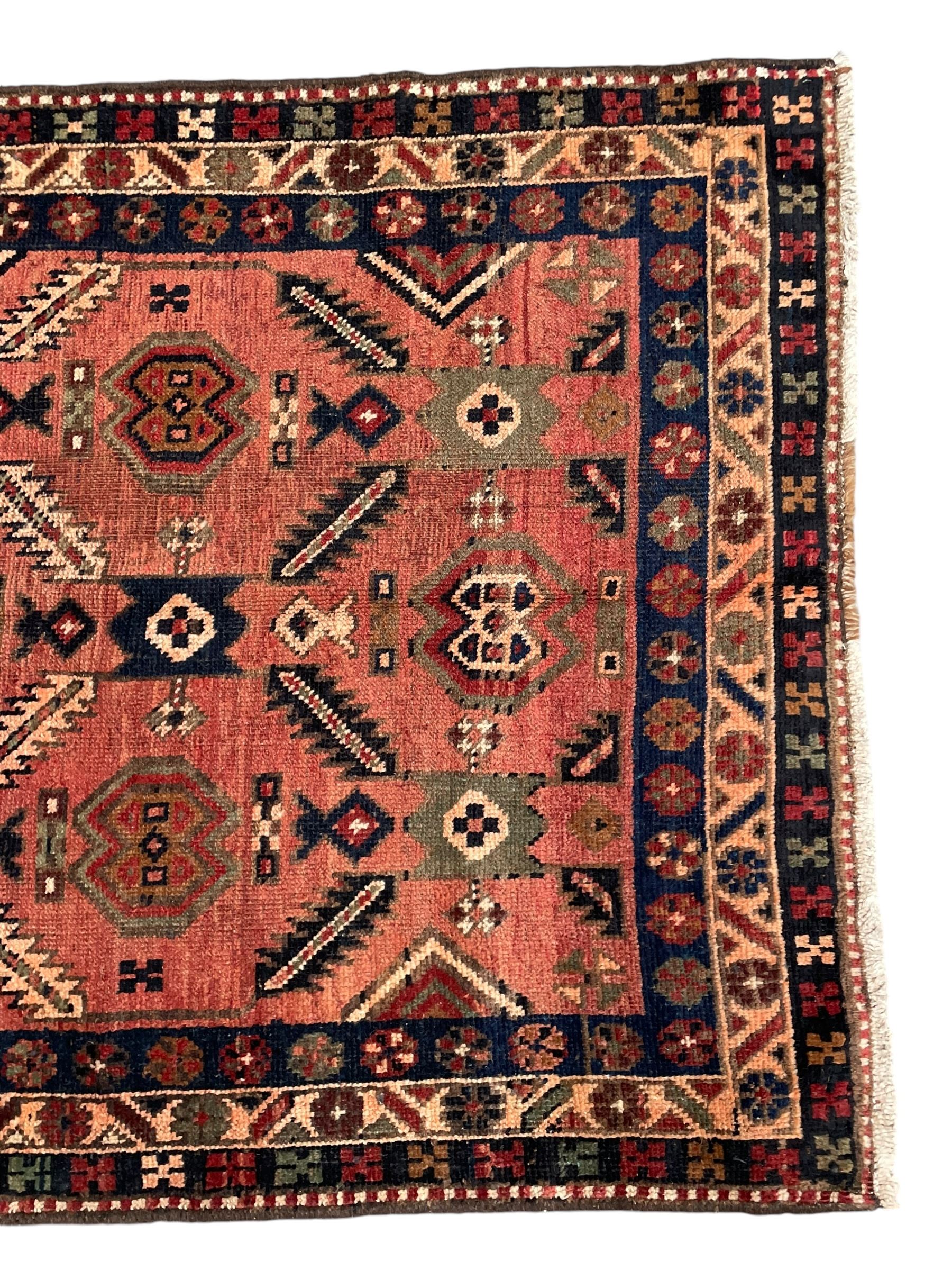 Near pair of Persian Azerbaijan red ground runners, each rug decorated with Nazarlik and stylised leaf motifs, enclosed with three band border decorated with flower heads and geometric motifs 

406cm x 99cm 
409cm x 102cm
