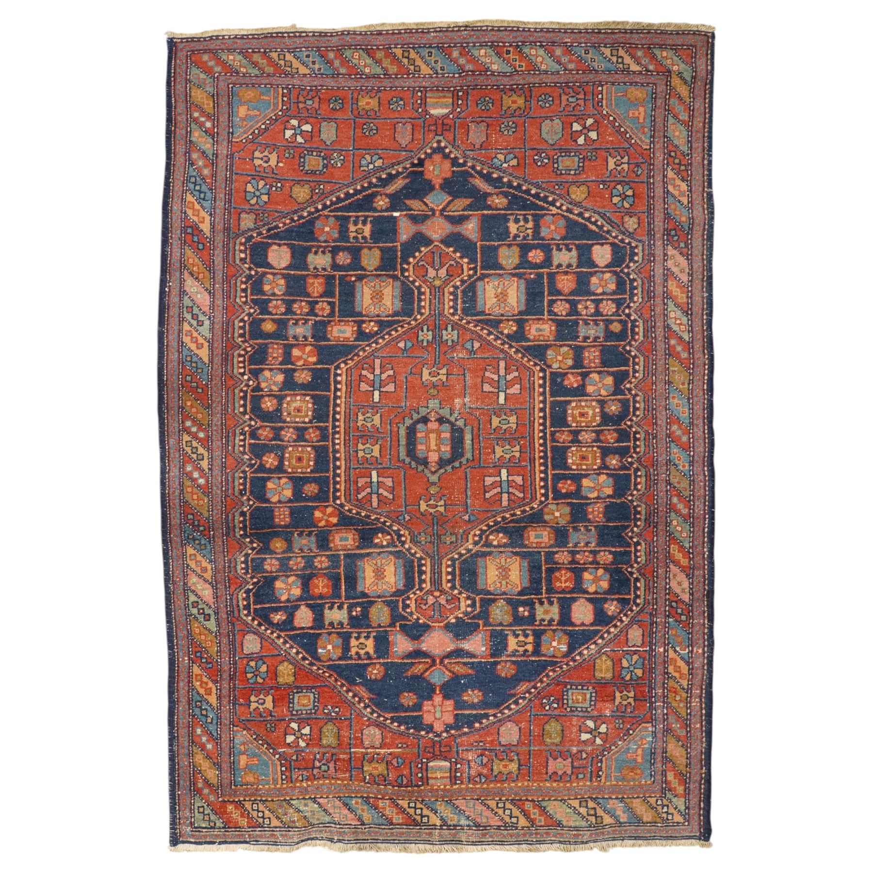 Persian Heriz hand-knotted carpet, terracotta ground centred by large dark navy geometric medallion with stepped outline, decorated throughout with stylised flowerheads, palmettes and geometric motifs in blue, green and ochre, enclosed by diagonal geometric border with narrow guard stripes