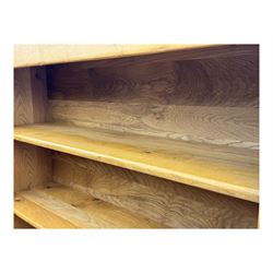 Contemporary French provincial design oak open bookcase, with projecting moulded cornice above a boarded back, fitted with four adjustable shelves, on bracketed plinth base