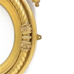 Regency gilt wood and gesso wall mirror, stag pediment with trailing oak leaves and acorns, extending curled acanthus leaves and fruiting vines, the convex mirror plate enclosed by rope twist and acanthus leaf decorated wreath